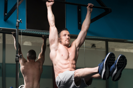 Athlete Performing Hanging Leg Raises Exercise - One Of The Most Effective Ab Exercisesの写真素材