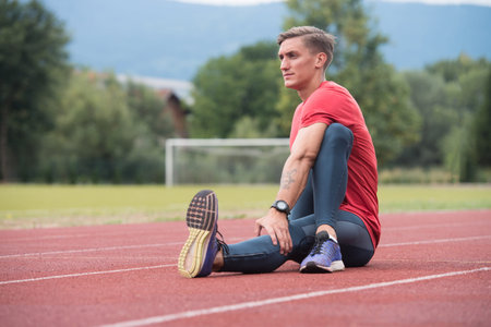 Young Athlete Man Relax and Strech Ready for Run at Athletics Race Track on Stadium