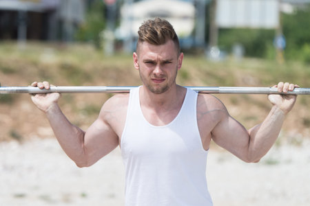 Athlete Working Out Legs In Nature With Barbell