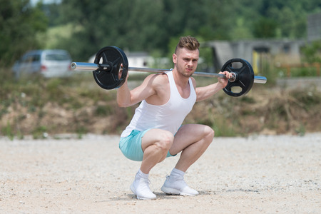 Athlete Working Out Legs In Nature With Barbellの写真素材