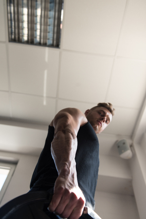 Portrait Of A Physically Young Man Holding Weights In Handの写真素材