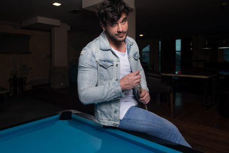 Portrait Of A Young Man Concentration On Ball In Pool Game Billiardの写真素材