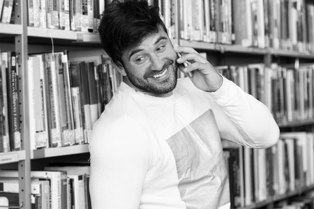 Student Talking on the Phone in Library at the Universityの写真素材