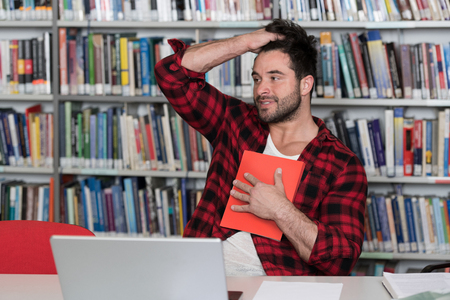 Young Man Student Feel Bored While Trying to Studying Entry Exams to University or Collegeの写真素材