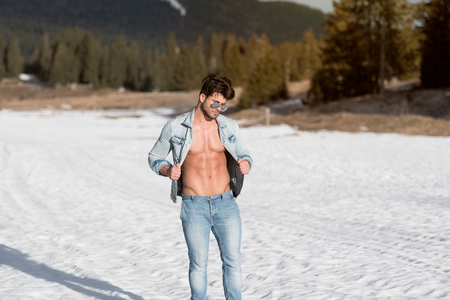 Handsome Young Model Standing Strong Outdoors and Flexing Muscles - Muscular Athletic Bodybuilder Man Posing - a Place for Your Textの写真素材