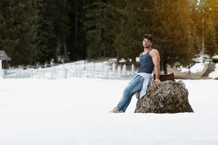 Healthy Young Man Standing Strong Flexing Muscles While Wearing Blue Jeans - Muscular Athletic Bodybuilder Fitness Model Posing Outdoors - a Place for Your Textの写真素材