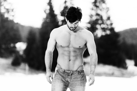 Handsome Young Model Standing Strong Outdoors and Flexing Muscles - Muscular Athletic Bodybuilder Man Posing - a Place for Your Textの写真素材