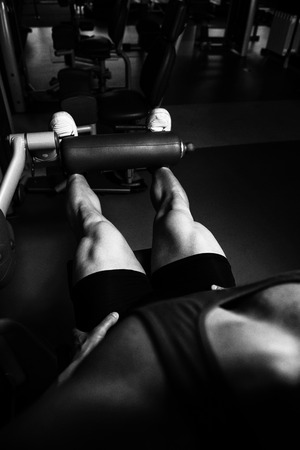 Leg Exercises Close Up -  Man Doing Leg With Machine In Gymの写真素材
