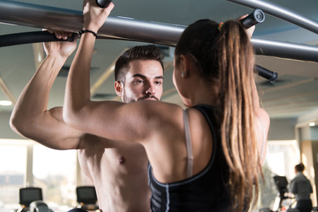 Young Couple Doing Heavy Weight Exercise For Pull Ups or Chin-ups
