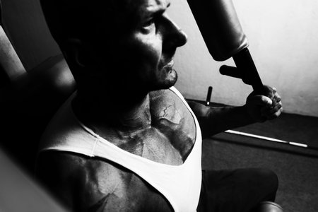 Handsome Muscular Fitness Bodybuilder Doing Heavy Weight Exercise For Chest On Machine In The Gym
