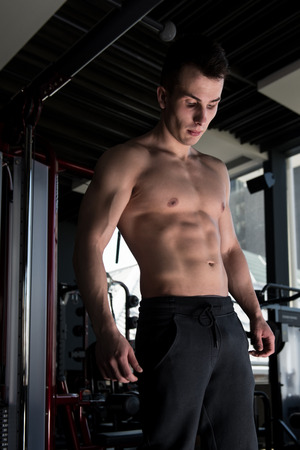 Portrait Of A Young Physically Fit Man Showing His Well Trained Body - Muscular Athletic Bodybuilder Fitness Model Posing After Exercisesの写真素材