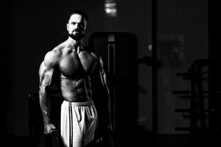 Portrait Of A Physically Young Man Holding Weights In Handの写真素材