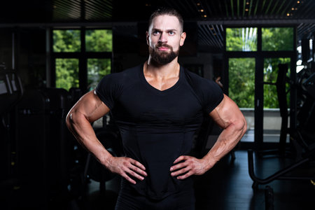 Portrait Of Personal Trainer In Sports Outfit In Fitness Center Gym Standing Strong