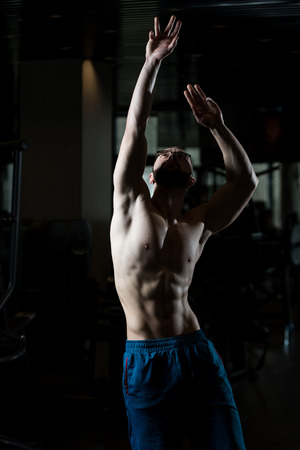 Portrait Of A Young Physically Fit Nerd Man Showing His Well Trained Body - Muscular Athletic Bodybuilder Fitness Model Posing After Exercisesの写真素材