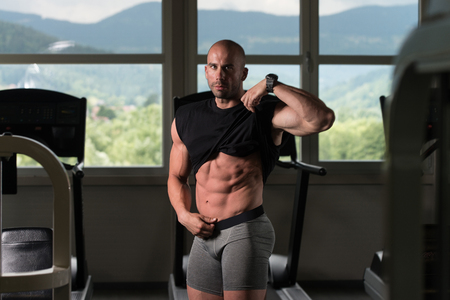 Portrait Of A Young Physically Fit Man Showing His Well Trained Body - Muscular Athletic Bodybuilder Fitness Model Posing After Exercisesの写真素材