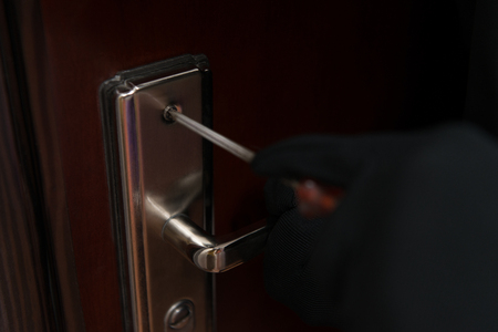Thief Burglar Force Lock Metal Door With A Tool During House Breakingの写真素材
