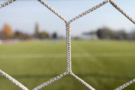 Soccer or Football Net Background - View From Behind the Goal With Blurred Stadium and Field Pitchの写真素材