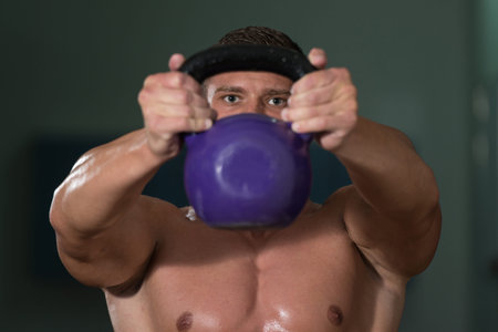 Athletic Man Workout With Kettle Bell