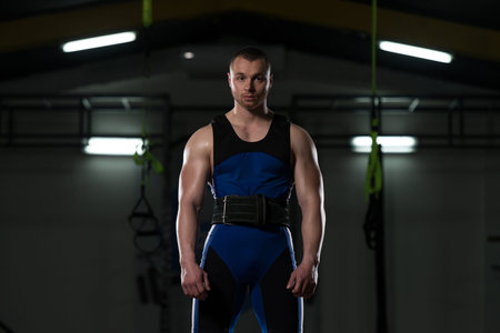 Portrait of Muscular Powerlifter Bodybuilder Fitness Model Standing Strong Posing After Exercises
