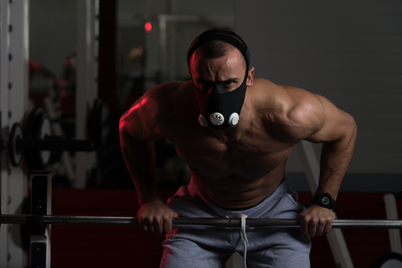 Bodybuilder Doing Push Ups On Barbell As Part Of Bodybuilding Training In Elevation Maskの写真素材