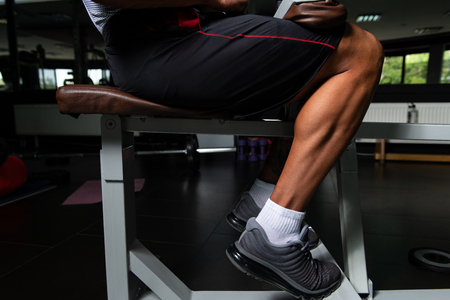 Muscular Man Exercising Calves On Machine In The Gymの写真素材