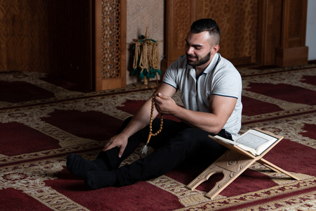 Businessman Muslim Is Reading The Koran Making Traditional Prayer to God Allah in the Mosqueの写真素材