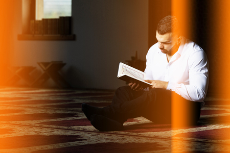 Attractive Muslim Is Reading The Koran Making Traditional Prayer to God Allah in the Mosqueの写真素材