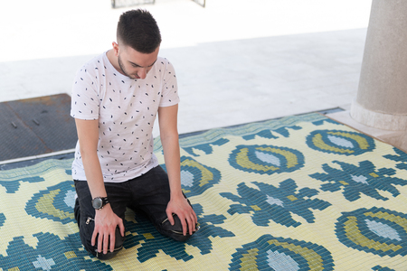 Attractive Man Making Traditional Prayer to God Allah Outdoors at Front the Mosqueの写真素材