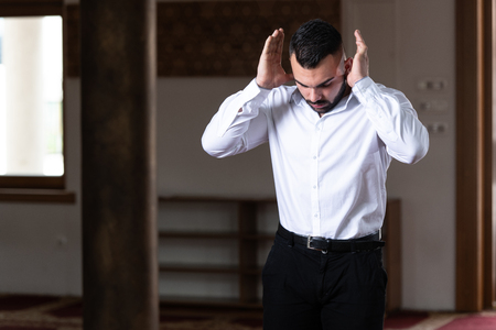 Attractive Man Making Traditional Prayer to God Allah in the Mosqueの写真素材