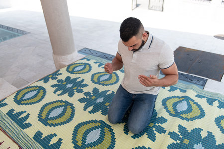 Muslim Man Making Traditional Prayer to God Allah in the Mosque