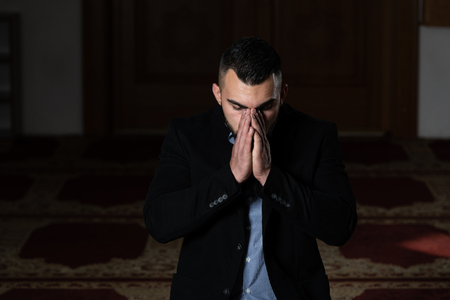 Attractive Man Making Traditional Prayer to God Allah in the Mosqueの写真素材