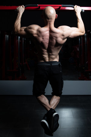Man Athlete Doing Pull Ups - Chin-Ups In The Gym