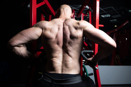 Handsome Athlete Doing Heavy Weight Exercise For Back On Machine