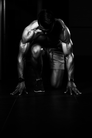 Strong Muscular Men Kneeling On The Floor - Almost Like Sprinter Starting Positionの写真素材