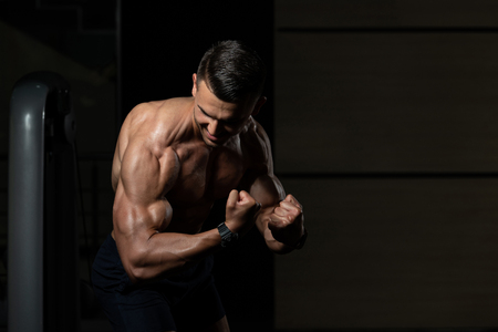 Portrait Of A Young Physically Fit Man Showing His Well Trained Body - Muscular Athletic Bodybuilder Fitness Model Posing After Exercisesの写真素材