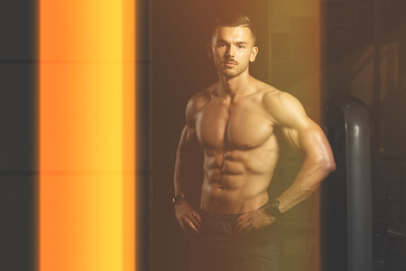 Portrait Of A Young Physically Fit Man Showing His Well Trained Body - Muscular Athletic Bodybuilder Fitness Model Posing After Exercisesの写真素材