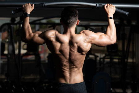 Man Athlete Doing Pull Ups - Chin-Ups In The Gym