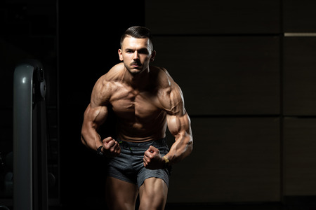 Portrait Of A Young Physically Fit Man Showing His Well Trained Body - Muscular Athletic Bodybuilder Fitness Model Posing After Exercisesの写真素材