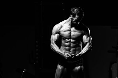 Portrait Of A Adult Physically Fit Man Showing His Well Trained Body - Muscular Athletic Bodybuilder Fitness Model Posing After Exercisesの写真素材