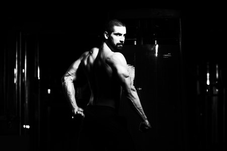 Handsome Young Man Standing Strong In The Gym And Flexing Muscles - Muscular Athletic Bodybuilder...