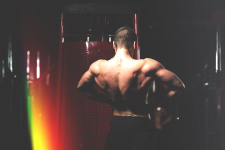 Young Man Standing Strong In The Gym And Flexing Muscles - Muscular Athletic Bodybuilder Fitness...