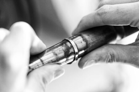 Jeweler Polishing A Gold Ring At Workbench - Goldsmith Making A Ring At Her Work Shop Using Toolsの写真素材