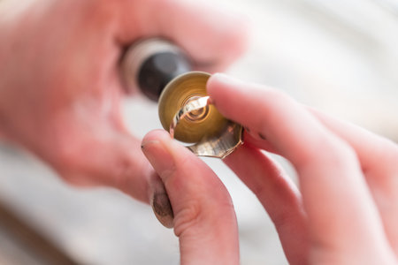Jeweler Polishing A Gold Ring At Workbench - Goldsmith Making A Ring At Her Work Shop Using Tools