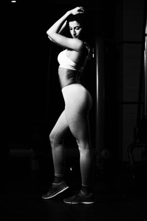 Portrait Of A Young Physically Fit Woman Showing Her Well Trained Body - Beautiful Athletic Fitness Model Posing After Exercisesの写真素材