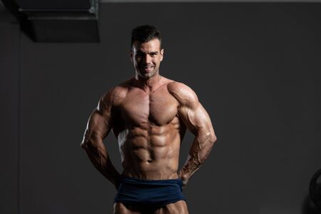Portrait Of A Young Physically Fit Man Showing His Well Trained Body - Muscular Athletic Bodybuilder Fitness Model Posing After Exercisesの写真素材