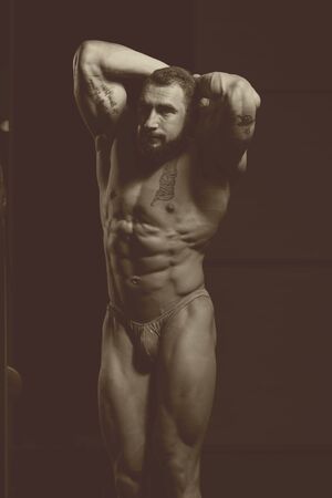 Portrait Of A Young Physically Fit Man Showing His Well Trained Body - Muscular Athletic Bodybuilder Fitness Model Posing After Exercisesの写真素材