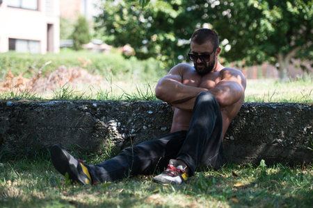 Handsome Mature Man Standing Strong Outdoors In Nature And Flexing Muscles - Muscular Athletic...