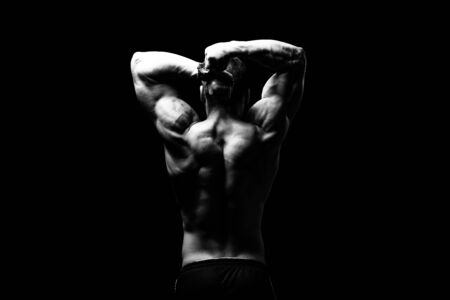 Young Bodybuilder Flexing Muscles - Isolate on Black Blackground - Copy Spaceの写真素材