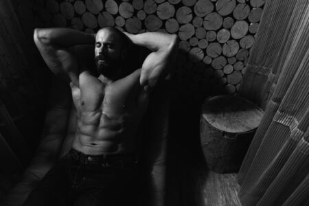 Happy Good Looking And Attractive Young Man With Muscular Body Relaxing In Hot Saunaの写真素材