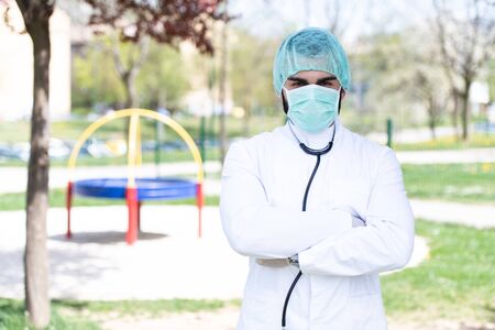 Portrait of a Tired Exhausted Male Caucasian Doctor in Front of a Park - Coronavirus Covid-19 Virus Disease - Global Pandemic Outbreakの写真素材